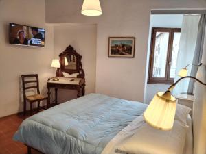 1 dormitorio con 1 cama con lámpara y escritorio en APPARTAMENTO CISTERNA 33, en San Gimignano