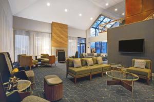 a living room with couches and a flat screen tv at Courtyard Chicago Elmhurst/Oakbrook Area in Elmhurst