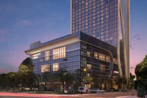 a large glass building with a tall skyscraper at Wenzhou Marriott Hotel in Wenzhou