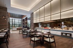 a restaurant with tables and a chef in the kitchen at Wenzhou Marriott Hotel in Wenzhou
