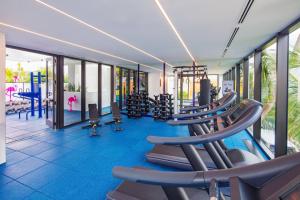 a gym with a row of treadmills and machines at Moxy Miami South Beach in Miami Beach