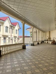 un patio vide avec des bâtiments blancs et un toit dans l'établissement Oscar, à Samarcande