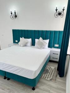 uma cama com uma cabeceira azul num quarto em Oscar em Samarkand