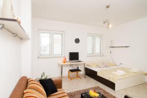 a white room with a bed and a desk at Dubrovnik Summer Apartments in Dubrovnik