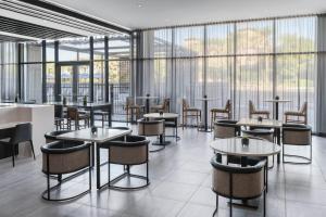 a restaurant with tables and chairs and windows at AC Hotel by Marriott Scottsdale North in Scottsdale