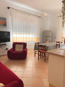 sala de estar con sofá rojo y mesa en ASSUMBRA Casa Vacanze, en Santa Maria Navarrese