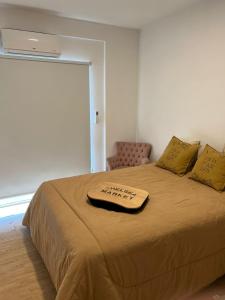 a bed with a brown blanket on top of it at PALERMO APART in Buenos Aires