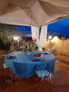 a blue table with chairs under a white tent at LA CASA DI GIADA in Impruneta