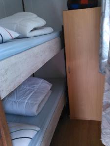 ein Etagenbett mit weißen Kissen darauf in der Unterkunft Stacaravanverhuur Kroon chalet B-10 in Workum