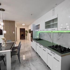 a kitchen with white cabinets and a green counter top at Dolce vita Prémium in Budapest