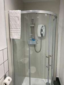 a shower with a glass door in a bathroom at Newly Renovated Ground Floor 1-Bed Flat in Bonhill