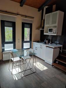 uma cozinha com uma mesa de vidro e cadeiras em la casa de las cabilas em Cuevas del Valle