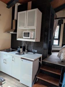 uma cozinha com armários brancos e um micro-ondas em la casa de las cabilas em Cuevas del Valle