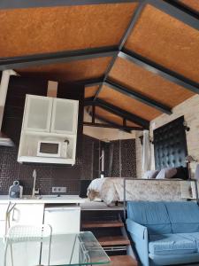 a room with a bed and a kitchen with a couch at la casa de las cabilas in Cuevas del Valle +3 photos