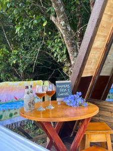 a table with two glasses of wine and a sign at Villa Feliz Ecolodge in Monterrey