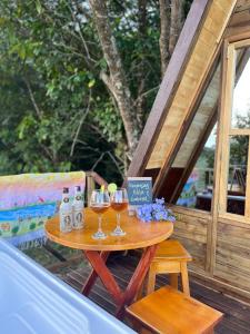 a table with two glasses of wine on a deck at Villa Feliz Ecolodge in Monterrey