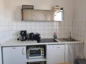 a small kitchen with a sink and a microwave at 1-Zimmer-Apartment "Meeresrauschen" in Peenemünde in Peenemünde