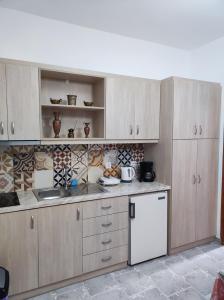 a kitchen with wooden cabinets and a white refrigerator at Blue Sea Studios in Arkasa