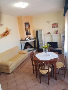 ein Wohnzimmer mit einem Sofa und einem Tisch in der Unterkunft Casa vacanza Tommy in Pabillonis