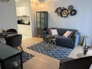 a living room with a blue couch and a table at APARTAMENT VELVET in Świnoujście