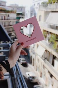 a person holding a piece of paper with a heart at Let me take my bunk bed in Athens