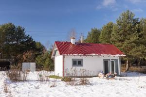 a small white house with a red roof in the snow at Nowy dom przy starym krześle - w Pelniku in Pelnik