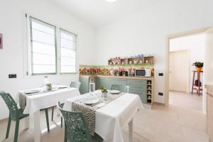 une salle à manger avec une table et des chaises blanches dans l'établissement B&b Casa Spano, à Selargius