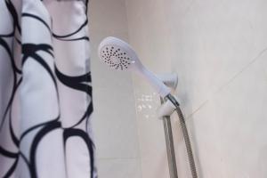 a shower head in a bathroom with a shower curtain at Les perles du bonheur Nyékonakpoé in Lomé +10 photos