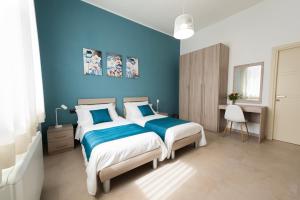 a blue bedroom with a bed and a desk at B&b Casa Spano in Selargius