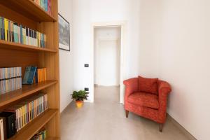 a living room with a red chair and bookshelves at B&b Casa Spano in Selargius