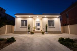 une grande maison blanche avec allée la nuit dans l'établissement B&b Casa Spano, à Selargius