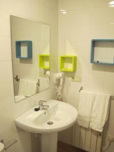 a bathroom with a sink and a mirror and towels at Apartamentos Turísticos Cancelas by Bossh Hotels in Santiago de Compostela +31 photos