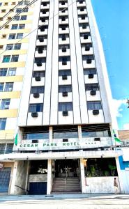 een hoog wit gebouw met een hotel bij César Park Hotel in Juiz de Fora