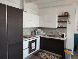 - une cuisine avec des placards blancs et un évier dans l'établissement Casa Twins, à Bari