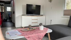 a living room with a table with a tv on a white cabinet at Casa Lira Baumberge in Billerbeck
