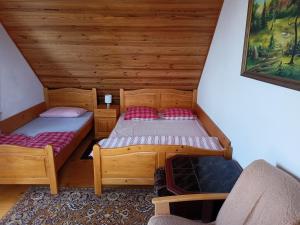 a room with two beds in a cabin at Podkamiencem in Odrzykoń