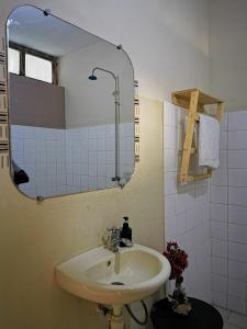 bagno con lavandino e specchio di Résidence Tichani Club a Cotonou