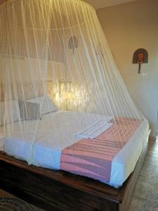 a bed with a net on top of it at Résidence Tichani Club in Cotonou