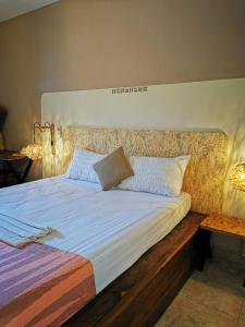 a bedroom with a large bed with a wooden headboard at Résidence Tichani Club in Cotonou