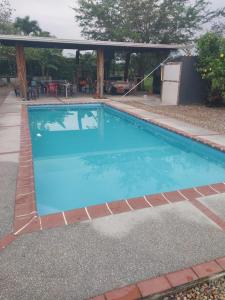 einen Pool mit blauem Wasser und eine Terrasse in der Unterkunft Cabañas alma llanera in Villavicencio