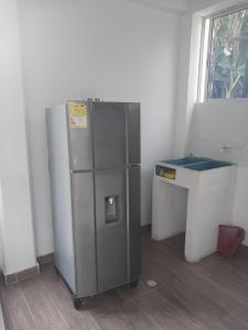 Zimmer mit einem Metallkühlschrank und einem Schreibtisch in der Unterkunft Cabañas alma llanera in Villavicencio