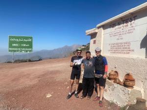 eine Gruppe von drei Personen, die vor einem Schild stehen in der Unterkunft Tizintest LA HAUTE VUE 2100M - Hôtel Restaurant in Mezdiout