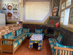sala de estar con sofá, sillas y chimenea en Tizintest LA HAUTE VUE 2100M - Hôtel Restaurant en Mezdiout