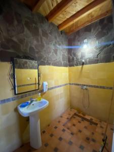 bagno con lavandino e specchio di Tizintest LA HAUTE VUE 2100M - Hôtel Restaurant a Mezdiout