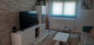 un salon avec une télévision à écran plat sur une armoire blanche dans l'établissement Alojamiento en Villamayor, à Villamayor