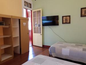 a bedroom with a bed and a tv on the wall at El Mirador De Valparaiso in Valparaíso