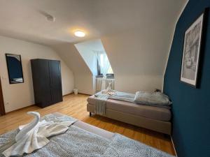 a bedroom with two beds and a blue wall at Comfortable Shared Apartment with Private Room in Wesseling in Wesseling