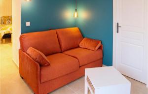 pomarańczowa kanapa w pokoju z niebieską ścianą w obiekcie Stunning Apartment In Villes Sur Auzon w mieście Villes-sur-Auzon