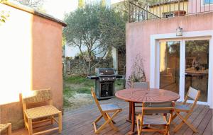 eine Terrasse mit einem Tisch, Stühlen und einem Grill in der Unterkunft Gorgeous Apartment In Villes Sur Auzon With Wifi in Villes-sur-Auzon