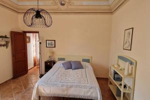 a bedroom with a bed and a chandelier at La Cava di Sasà in Favignana